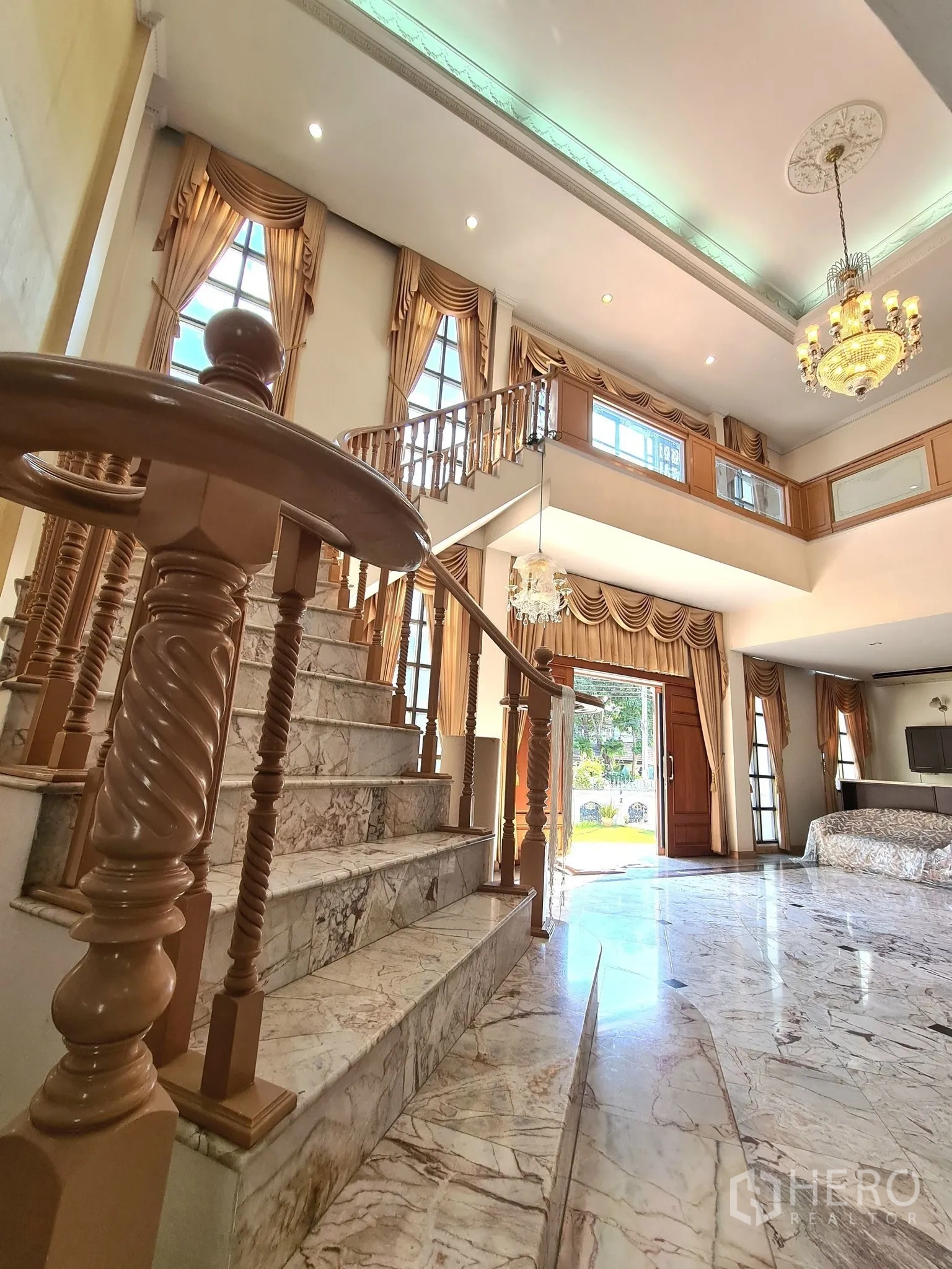 Detached House for sale in Chatuchak, Bangkok - Close-up of marble staircase leading to a sunlit foyer with tall drapes.