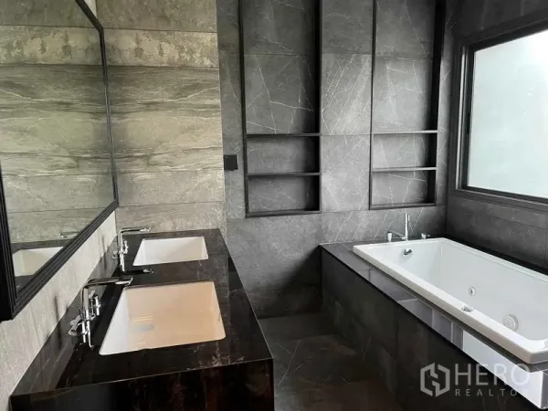 Detached House for sale in Bang Kruai, Nonthaburi - Master bathroom with double vanity, deep bathtub and gray stone tiles.
