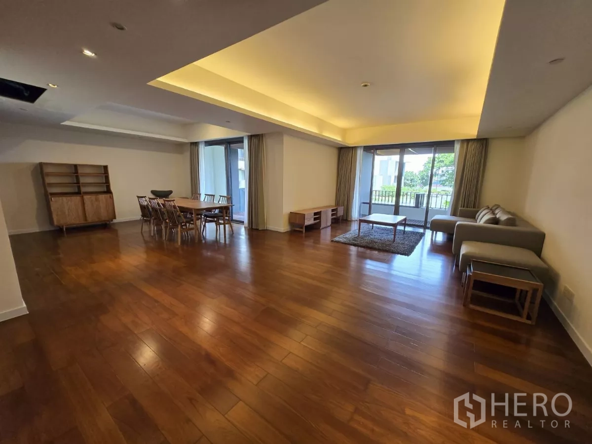 公寓 出租在Yan Nawa, Bangkok - 开放式客餐厅，嵌入式照明、木地板与大窗户连接阳台。