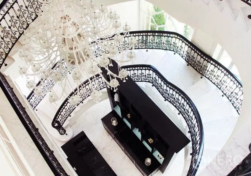 Condominium for sale in Watthana, Bangkok - Grand condominium lobby with ornate chandelier and curved wrought-iron staircase.