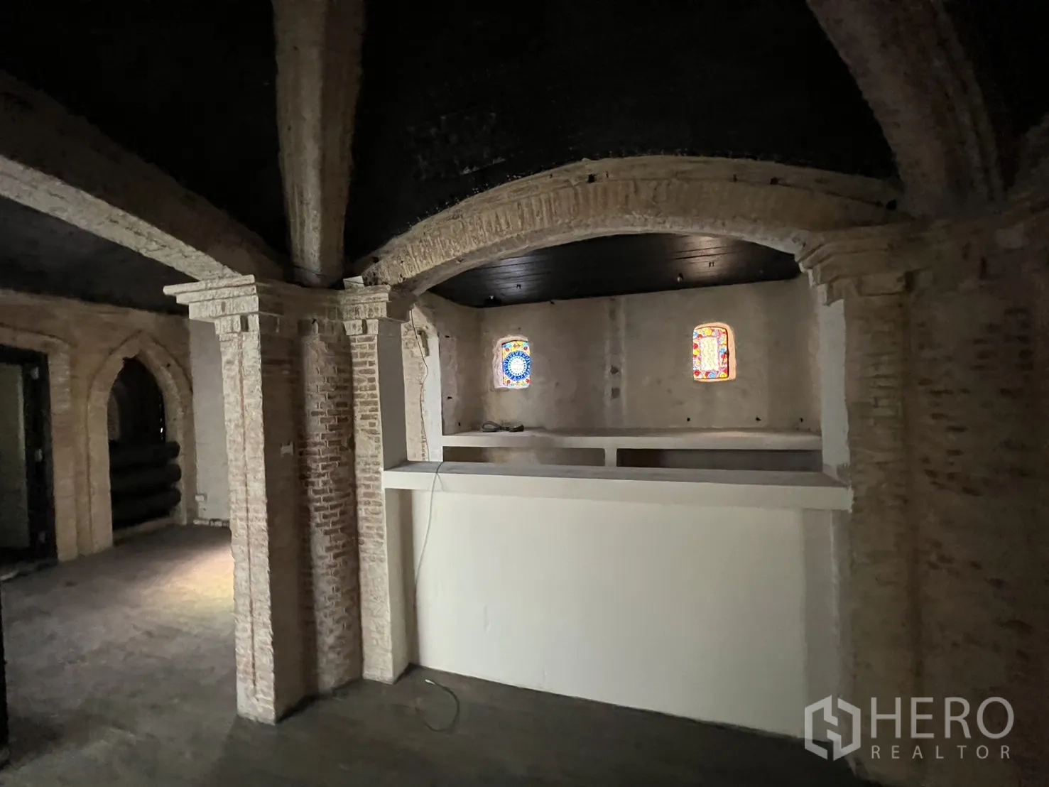 Retail Space for rent in Watthana, Bangkok - Interior space with brick arches and small stained-glass windows behind a service counter.