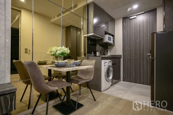 Condominium for rent in Watthana, Bangkok - Compact kitchenette with cabinets, microwave, washer and a dining set.