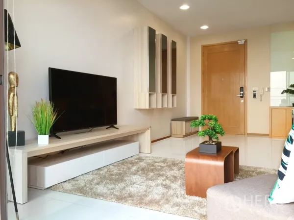 公寓 出租或出售在Khlong Toei, Bangkok - 客厅媒体墙，配大屏电视、收纳柜与入户门。
