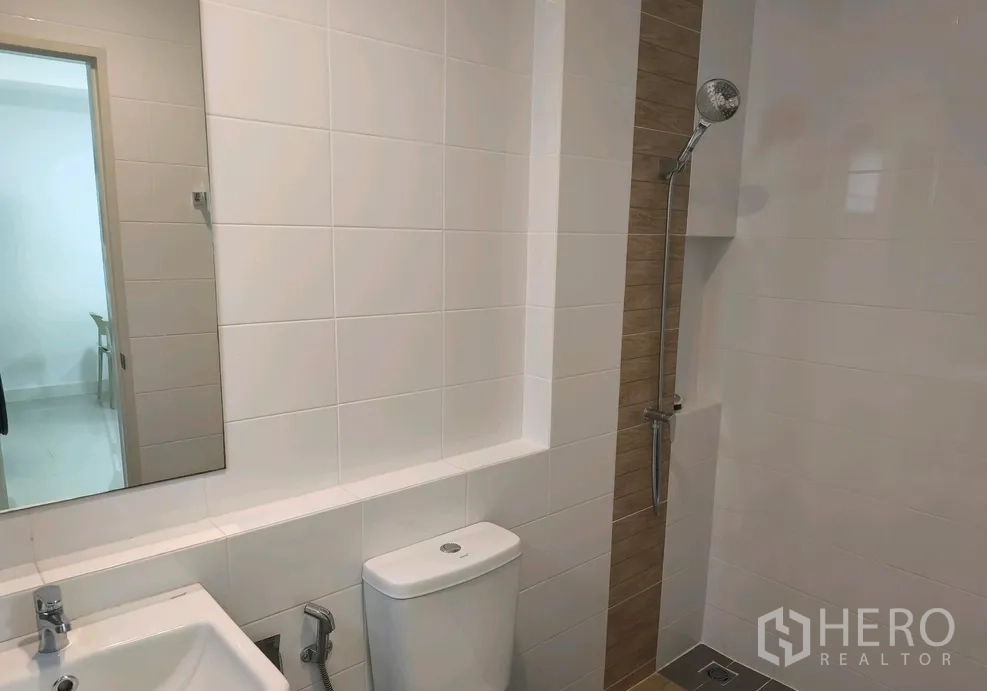 联排别墅 for rent in Bang Phli, Samut Prakan - 浴室配白色瓷砖、洗手盆、坐便与步入式淋浴位。