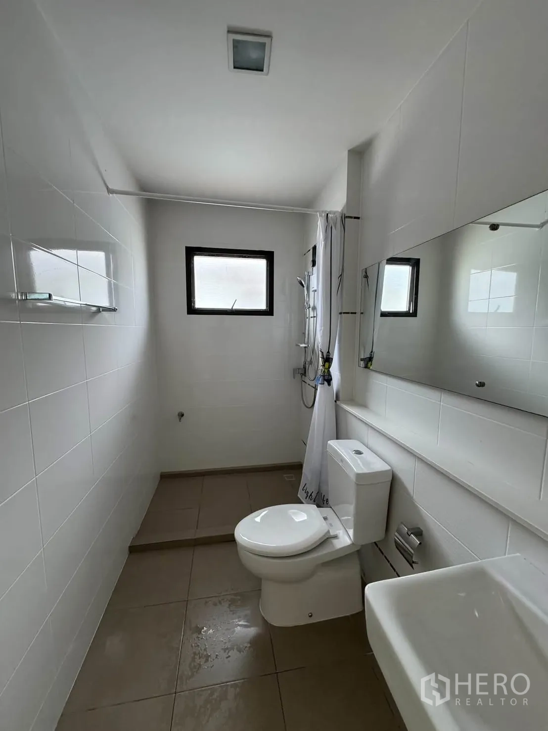 Detached House for rent in Prawet, Bangkok - Second bathroom with tiled walls, toilet, sink, and a raised shower area.