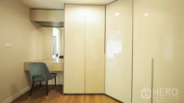 Condominium for rent in Khlong San, Bangkok - Built-in glossy wardrobes with a vanity desk and mirror in a dressing area.