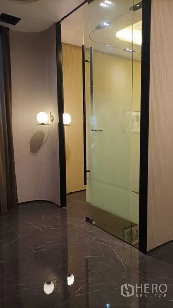 Retail Space for rent - Glass-walled private room with wall sconces and reflective marble-look floor.