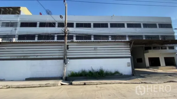 Factory for rent in Bang Phli, Samut Prakan - Street-side exterior of a two-storey factory with ventilation blocks and a gated driveway in Bang Phli.