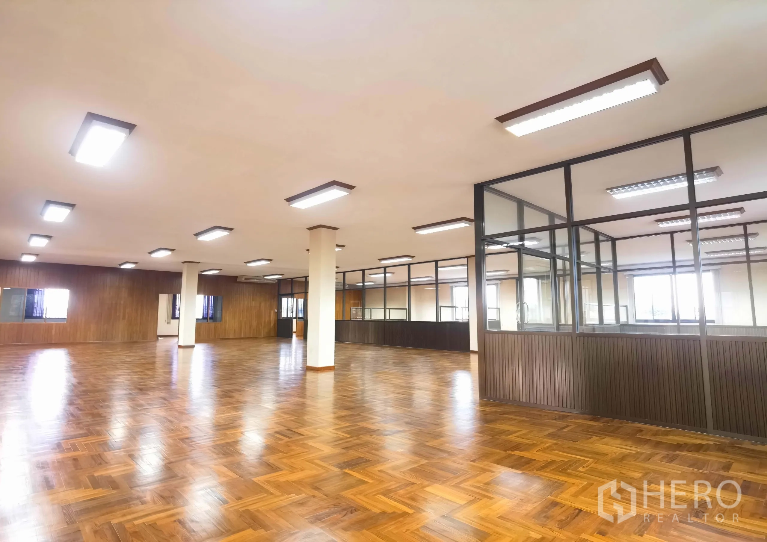 Warehouse for rent in Samut Prakan - Open‑plan office level with glass‑partition meeting rooms and wooden wall finishes.