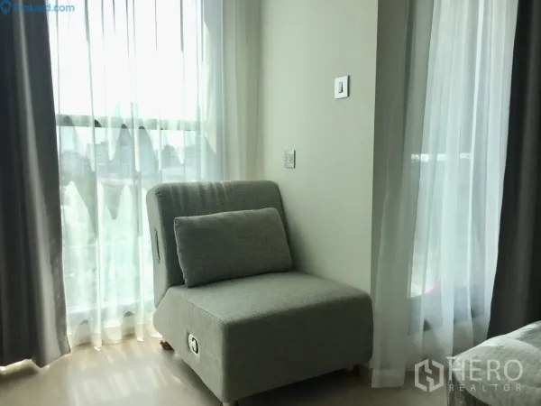 公寓 出租在Ratchathewi, Bangkok - 灰色休闲椅靠落地窗，透过纱帘引入充足自然光与城市景观。