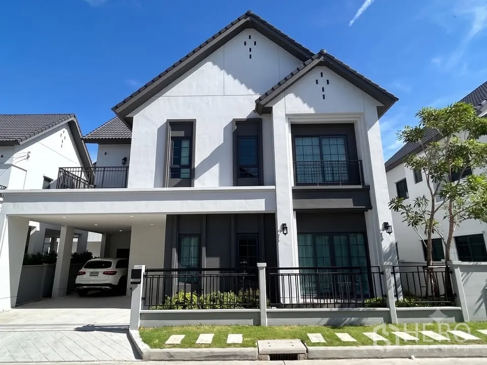 บ้านเดี่ยว for rent in Bang Phli, Samut Prakan - บ้านเดี่ยวสองชั้นสไตล์โมเดิร์น มีโรงจอดรถในร่ม สนามหญ้าหน้าบ้าน และหน้าต่างกรอบดำ