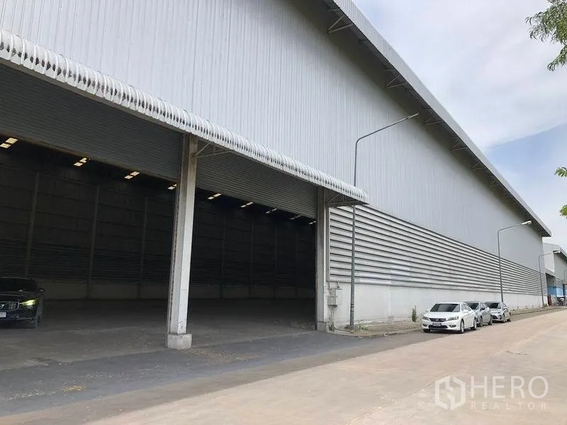Warehouse for rent in Phra Nakhon Si Ayutthaya - Covered loading bays along a long warehouse facade with a wide driveway for trucks.