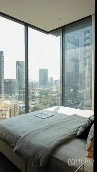 公寓 出租或出售在Watthana, Bangkok - 转角卧室，落地玻璃带来曼谷天际线全景。