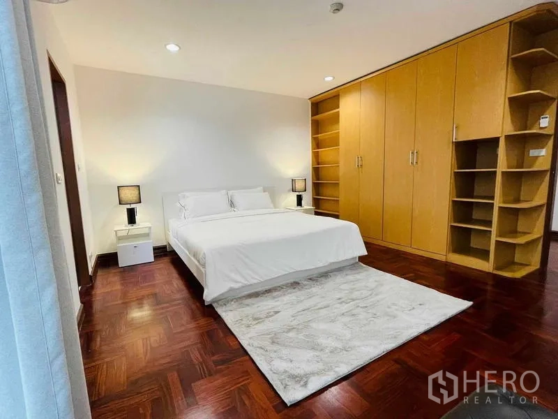 Condominium for rent - Primary bedroom featuring built-in wooden wardrobes and shelving.