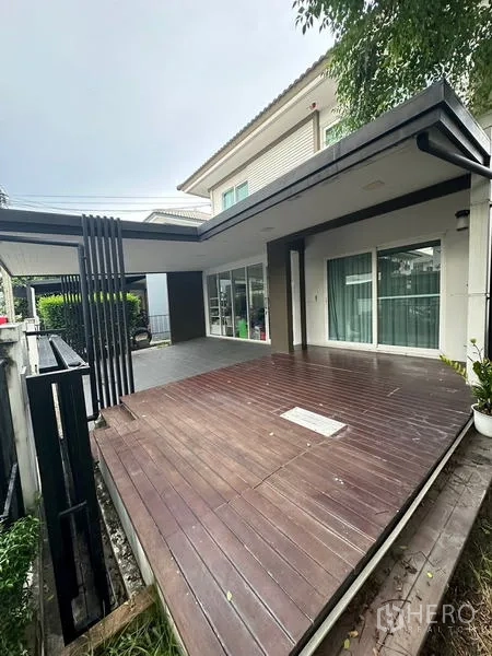 บ้าน ขายในPrawet, Bangkok - ระเบียงไม้ข้างประตูกระจกบานเลื่อนติดกำแพงโครงการ.