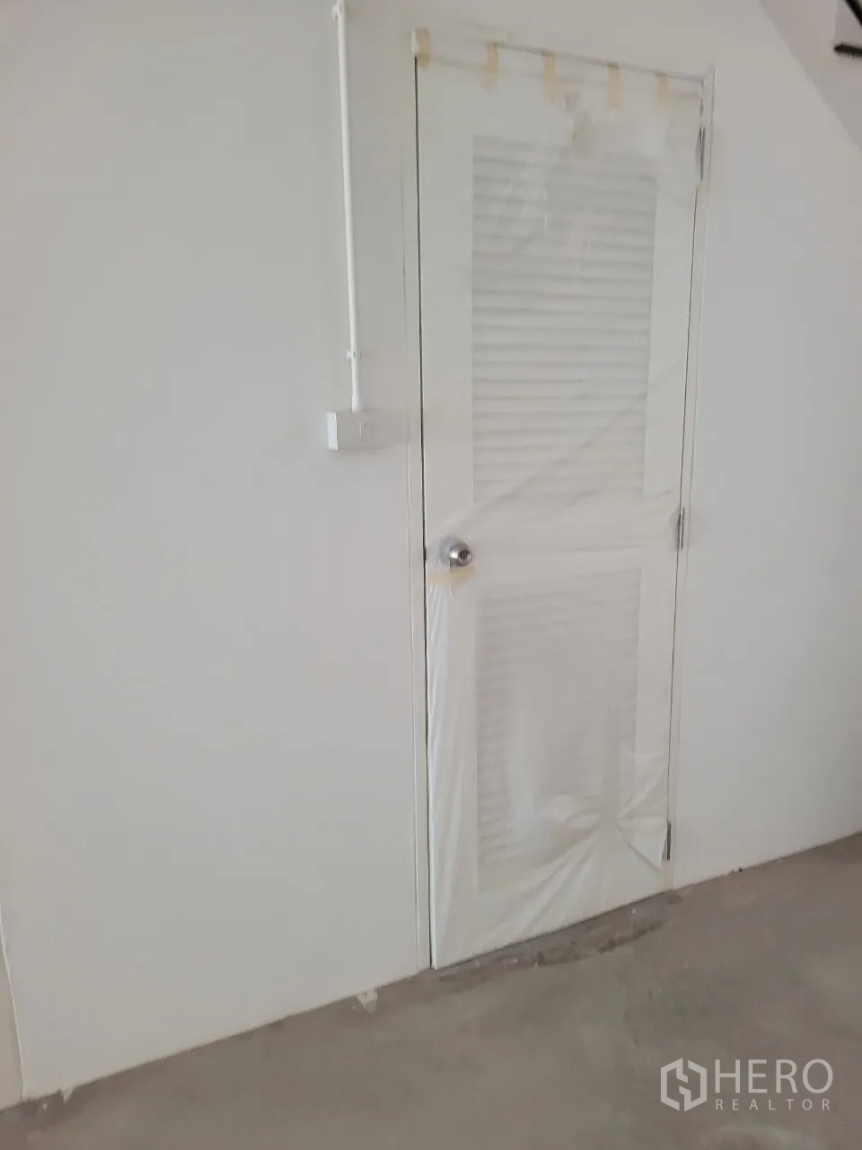 Shophouse for rent in Khlong Toei, Bangkok - Close-up of a louvered utility door located beneath the staircase inside the shophouse.
