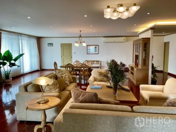 公寓 出租或出售在Watthana, Bangkok - 瓦他那区公寓宽敞客餐厅，木地板、中性色沙发与整面采光窗。