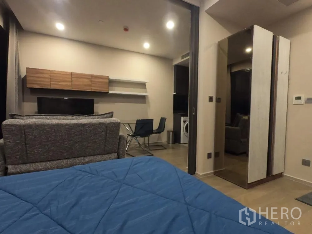 คอนโด for rent in Watthana, Bangkok - พื้นที่นอนแบบโอเพ่นแพลน มองไปยังผนังทีวี โซฟา และโต๊ะอาหารกระจกใกล้ครัว
