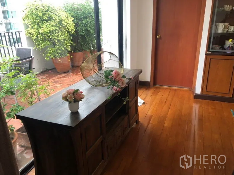Condominium for sale - Corner room opening to a leafy terrace with potted plants and terracotta tiles.