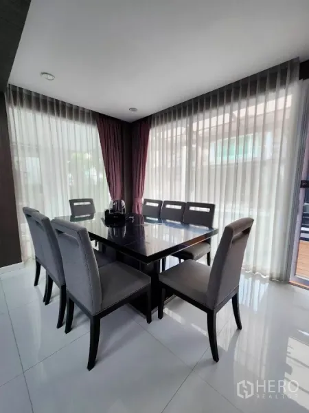 Detached House for rent or sale in Chatuchak, Bangkok - Bright dining area with corner floor-to-ceiling windows and eight-seat table.