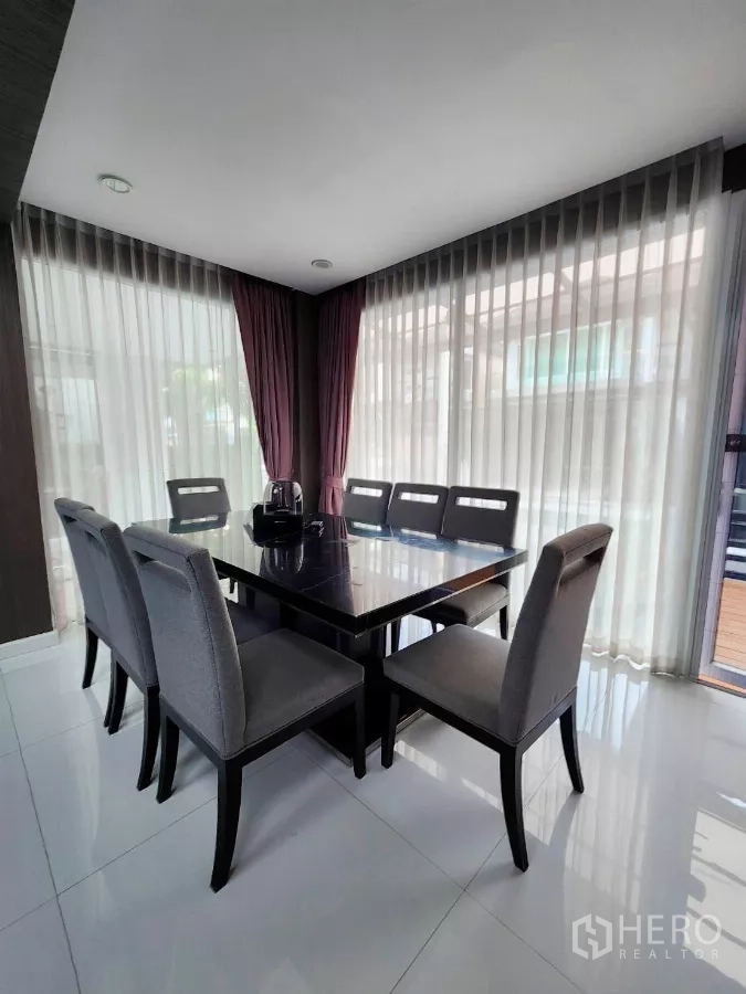 Detached House for rent or sale in Chatuchak, Bangkok - Bright dining area with corner floor-to-ceiling windows and eight-seat table.