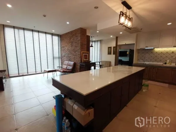 公寓 出租或出售在Bang Rak, Bangkok - 宽敞客餐厨一体，长条大理石中岛，砖纹特色墙与落地百叶窗。