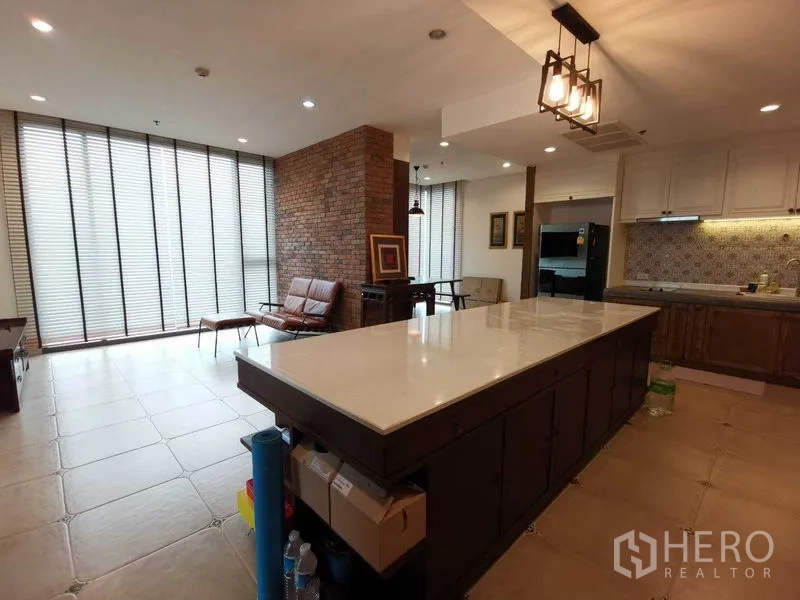 公寓 出租或出售在Bang Rak, Bangkok - 宽敞客餐厨一体，长条大理石中岛，砖纹特色墙与落地百叶窗。