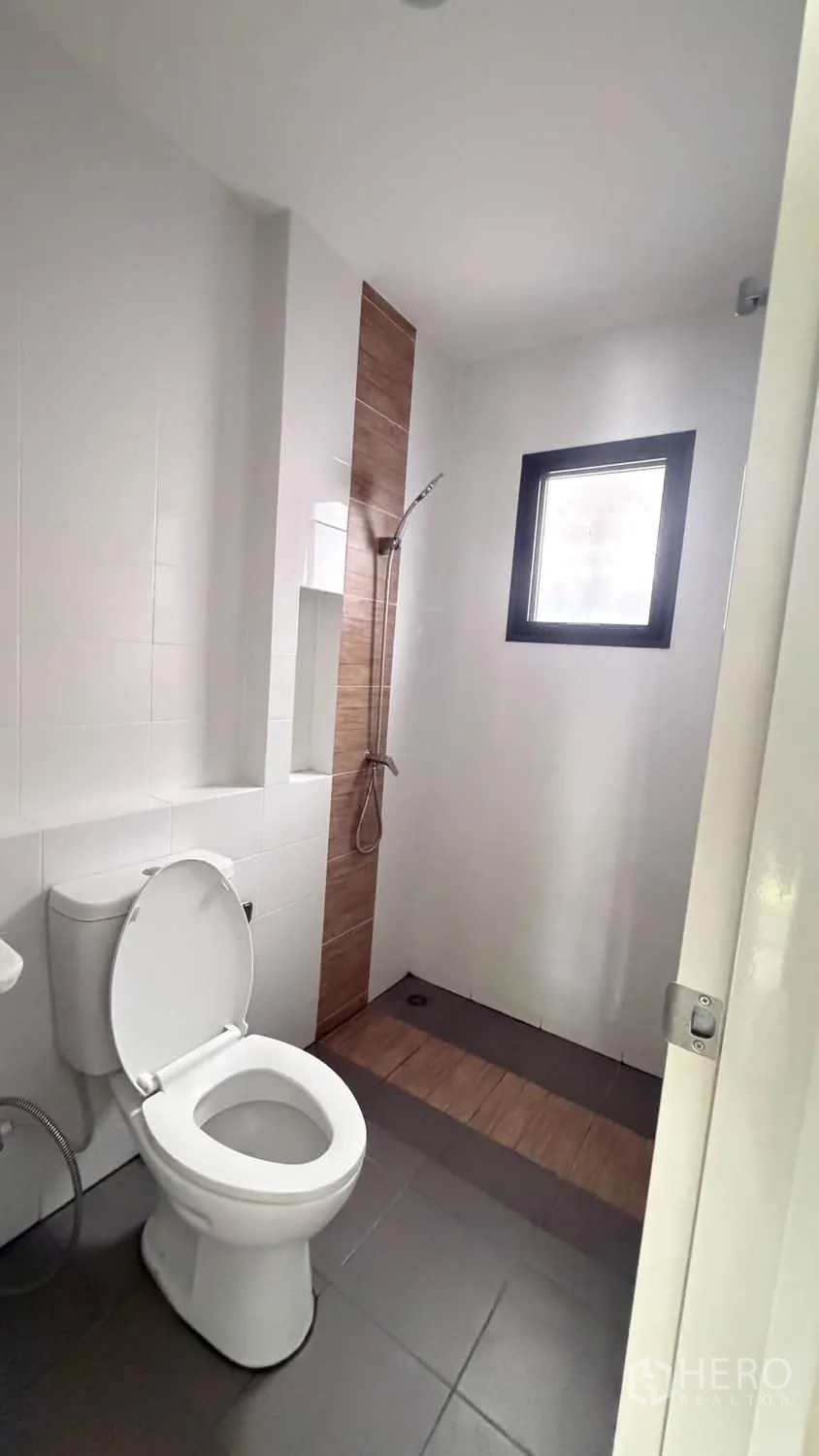Townhouse for rent in Bang Phli, Samut Prakan - Bright bathroom with a walk-in shower, tiled walls, and a window.