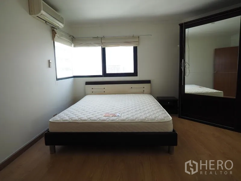 Condominium for rent in Sathon, Bangkok - Guest bedroom with bed, air conditioner and full-height mirrored wardrobe.