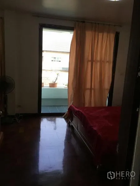 独立式住宅 出租或出售在Huai Khwang, Bangkok - 卧室通过推拉门通向阳台，配桃色窗帘。