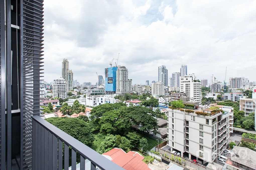 公寓 出租在Watthana, Bangkok - 带百叶遮阳的阳台，俯瞰树梢与曼谷天际线。