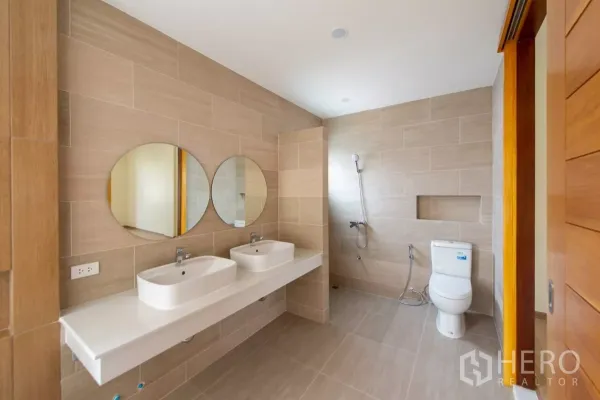 Townhouse for sale in Lat Phrao, Bangkok - Large bathroom with twin basins, round mirrors and a separate shower zone.
