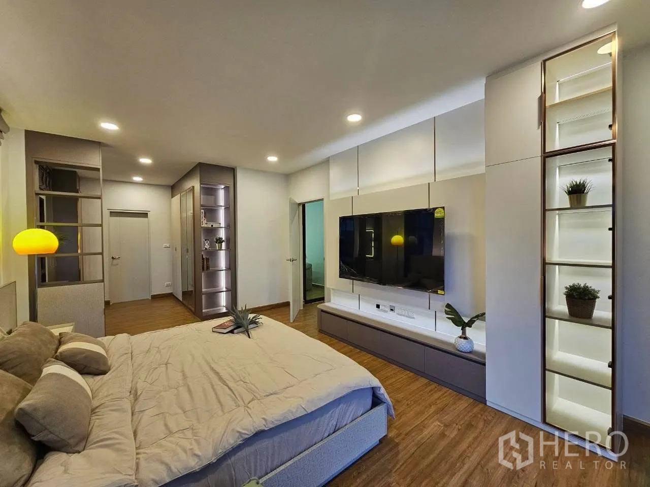 Detached House for rent or sale in Bang Phli, Samut Prakan - Large bedroom with feature TV wall, display shelves, and king bed.