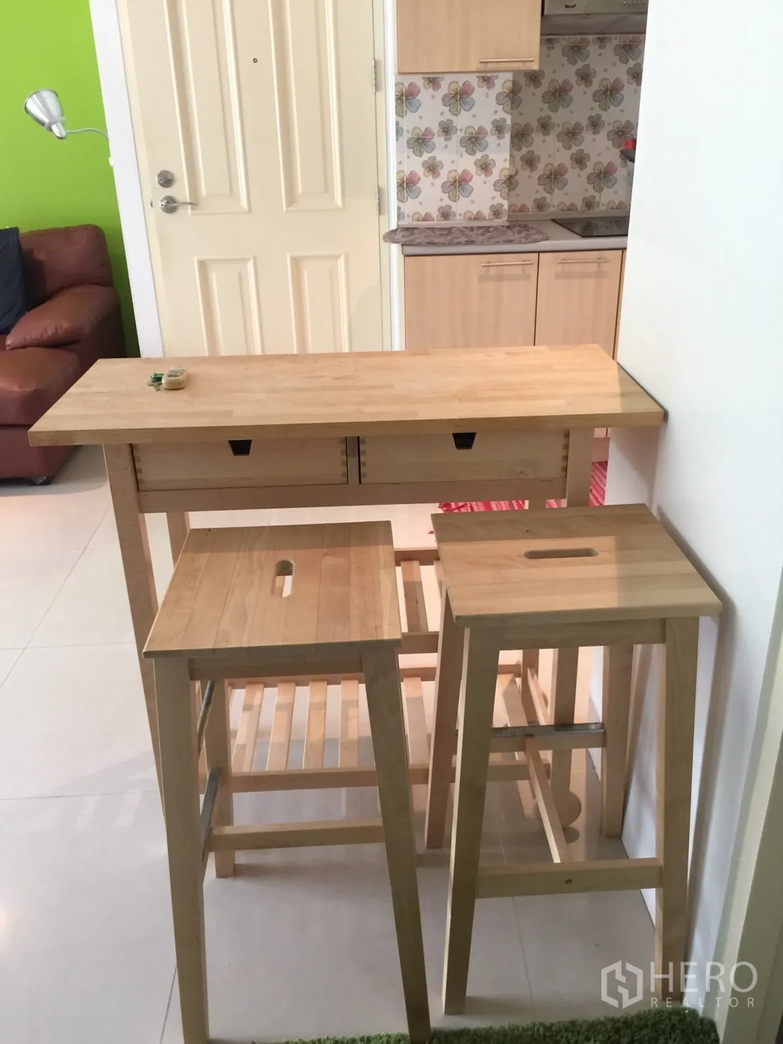 Condominium for rent in Khlong Toei, Bangkok - Wooden breakfast bar with stools beside the entrance and kitchenette.