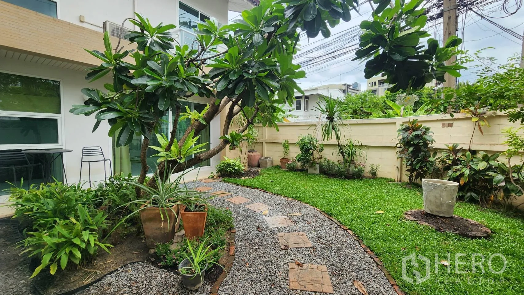 Detached House for rent in Watthana, Bangkok - Curved gravel path through a green yard beside the detached house.