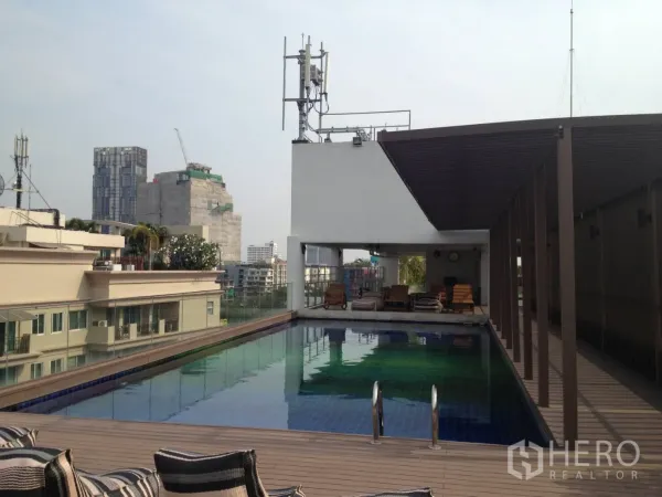 Condominium for rent in Khlong Toei, Bangkok - Rooftop swimming pool with sun deck and pergola overlooking the Bangkok skyline.