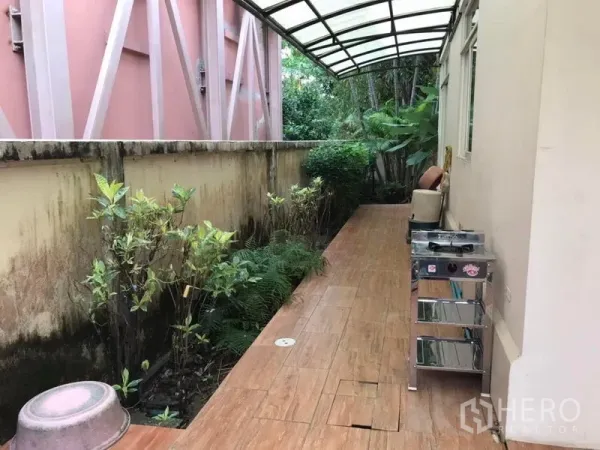 独立式住宅 出租在Bang Khen, Bangkok - 带顶侧院，铺砖步道，户外操作台与墙边绿植。