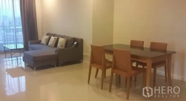 公寓 出租或出售在Ratchathewi, Bangkok - 采光充足的客餐厅，灰色转角沙发、四人餐桌与落地窗。