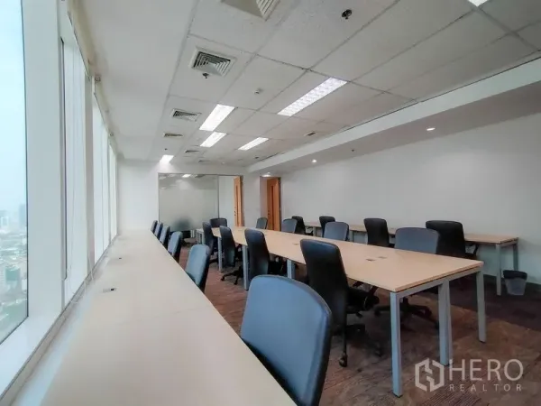 Office Space for rent in Khlong Toei, Bangkok - Open-plan office with long workstations, ergonomic chairs and a wall of windows with city views.