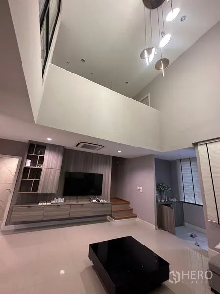 联排别墅 出售在Saphan Sung, Bangkok - 从客厅仰望夹层，吊灯垂落于挑空区域。