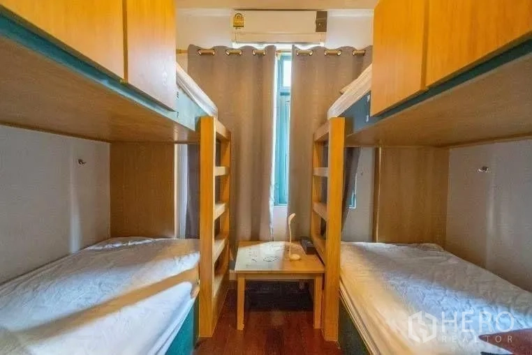 Detached House for rent in Khlong Toei, Bangkok - Compact bedroom featuring built-in wooden bunk beds and a curtained window.