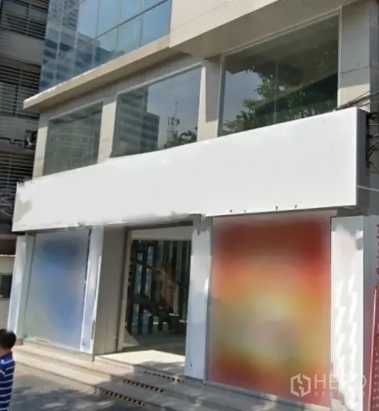 Retail Space for rent in Bang Rak, Bangkok - Modern commercial building with large glass facade and blank signage at street level.