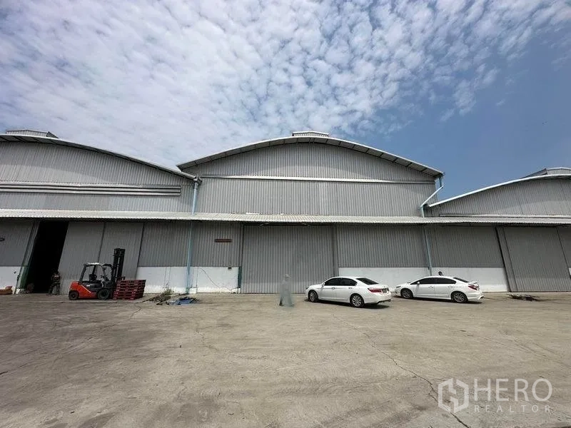 Warehouse for rent in Bang Pa-in, Phra Nakhon Si Ayutthaya - Main facade with loading bay, forklift area and several parked cars.