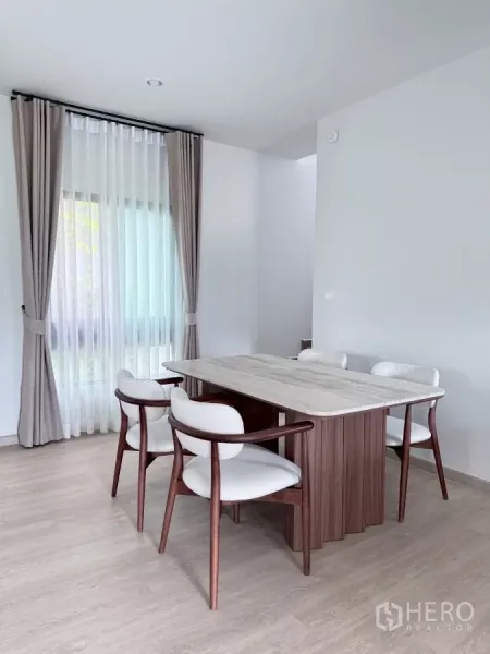 Detached House for rent in Lat Krabang, Bangkok - Sunny dining corner with six-seat table, wood floor and full-height drapes.