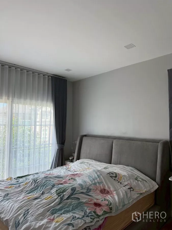Detached House for rent in Bang Phli, Samut Prakan - Master bedroom with upholstered bed, sheer curtains and balcony access.