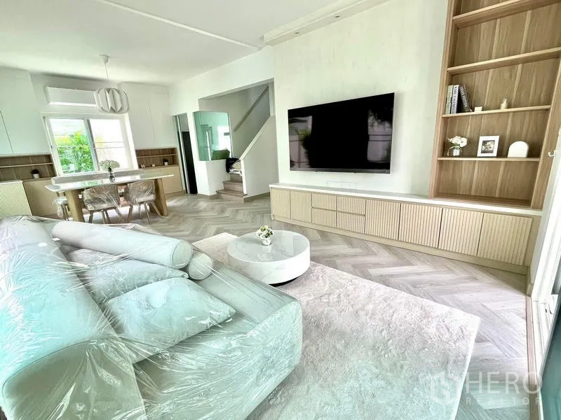 Detached House for rent - Living room view with built-in media cabinet, shelving, rug and staircase leading upstairs.