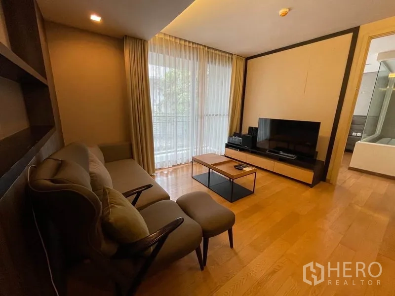 公寓 出售在Watthana, Bangkok - 客厅视角，面对电视柜与卧室门旁的大窗。