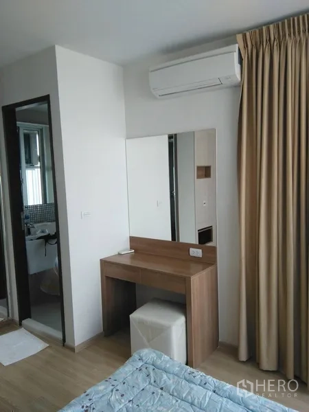 公寓 出租或出售在Sathon, Bangkok - 卧室梳妆台与镜子，紧邻浴室门与窗帘。