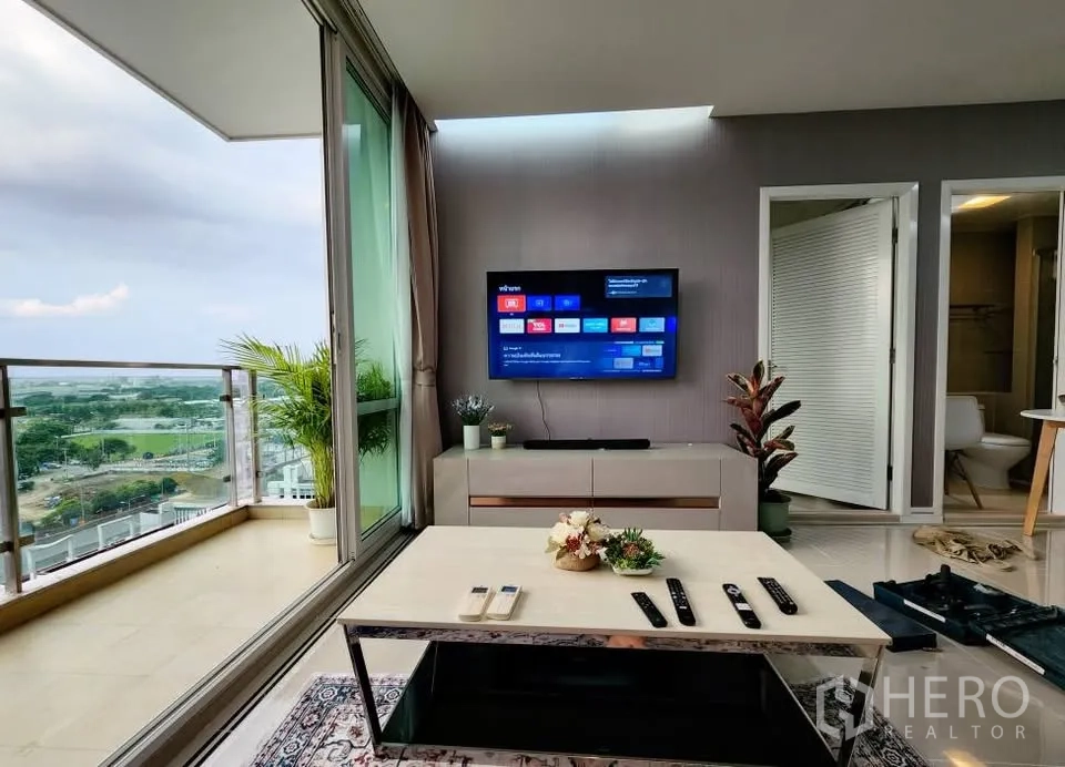 Condominium for rent in Huai Khwang, Bangkok - Corner living room opening to large balcony with pool and skyline views at TC Green Rama 9.