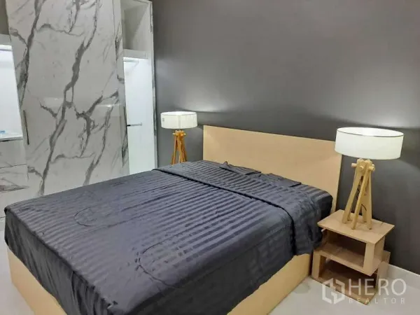 公寓 出租在Khlong Toei, Bangkok - 主卧配深色背景墙，灰色床品，三脚落地灯及大理石衣柜。